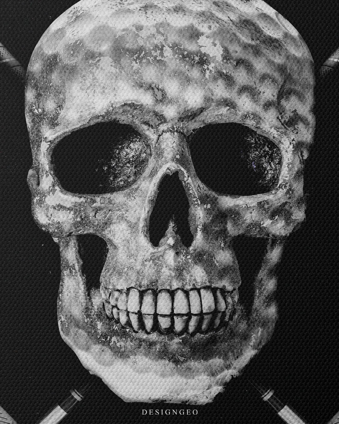 Medium shot showing the detailed dimpled golf ball surface texture on a white skull with crossed golf clubs on a dark canvas background