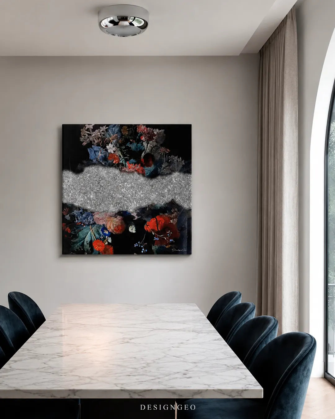 Square dark floral with silver diamonds canvas wall art mounted on a beige wall in a modern dining room above a white marble table with dark blue velvet chairs