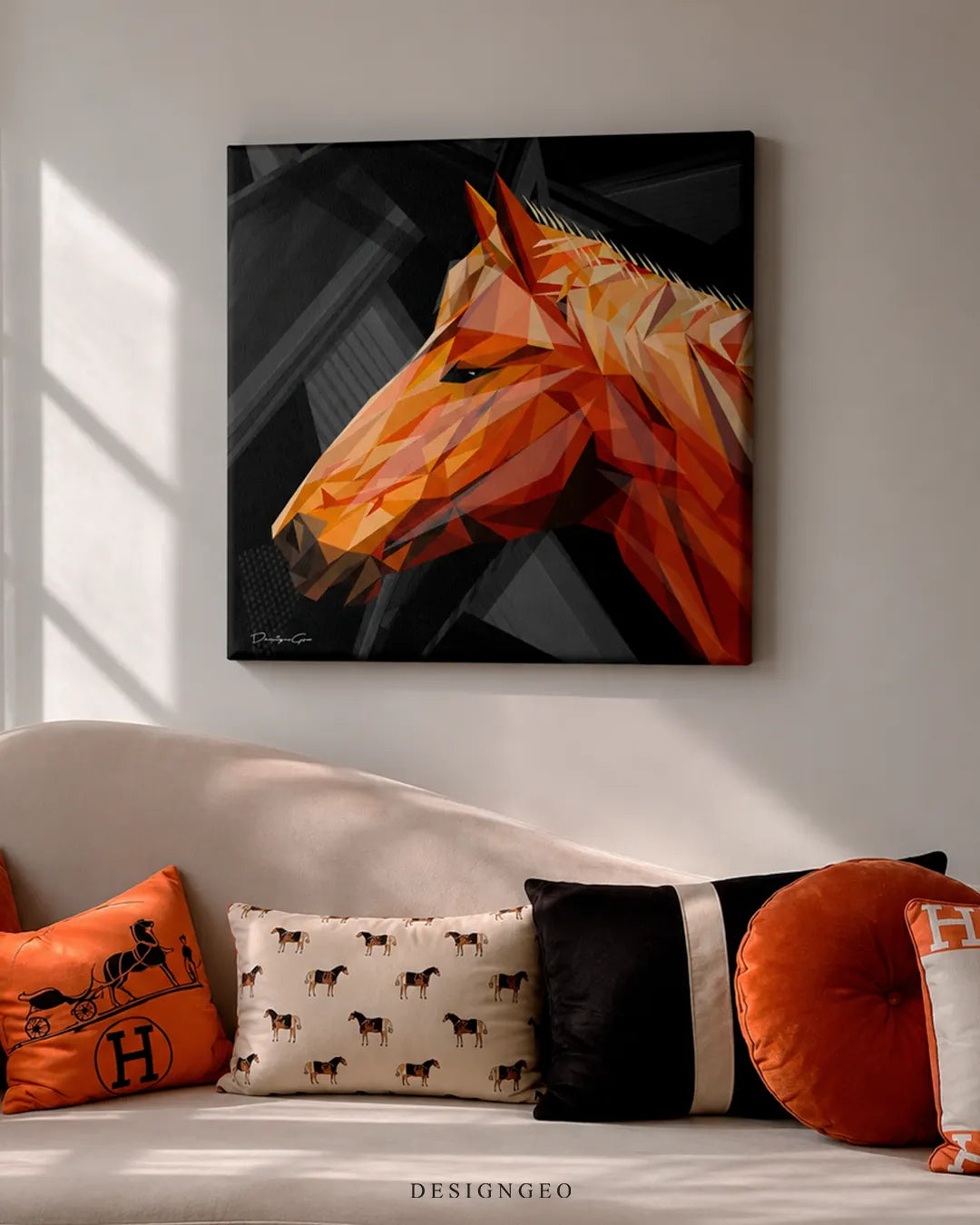 Square geometric orange horse canvas print mounted on a beige wall above a curved cream sofa styled with equestrian horse-patterned and orange velvet pillows