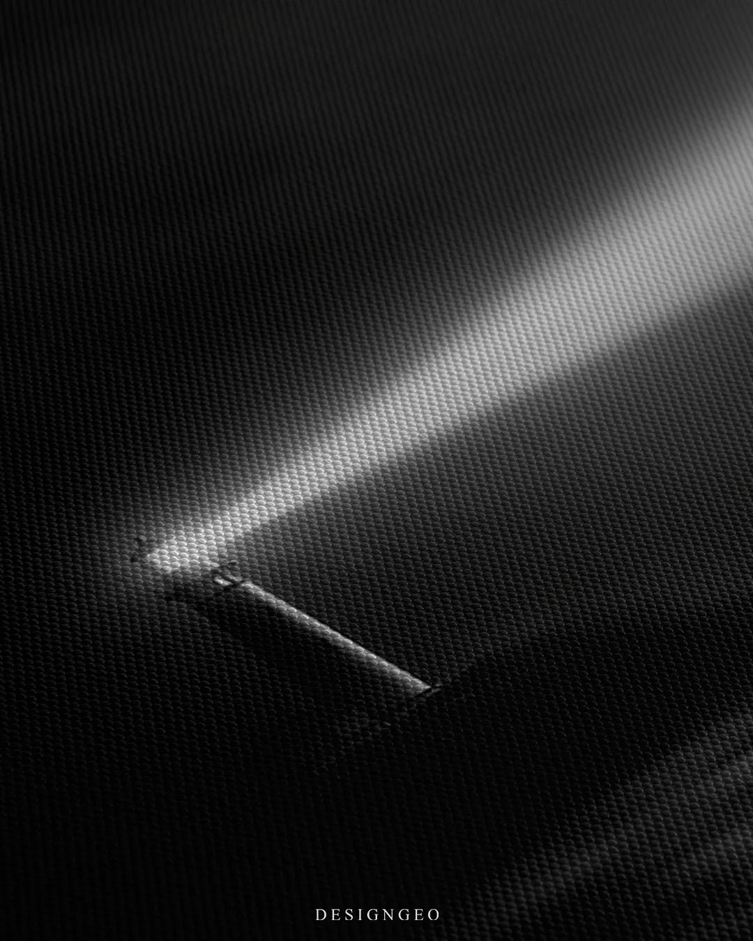 Angled detailed macro texture of woven canvas print showing lighthouse beam and Outshine The Noise typography quote on dark background