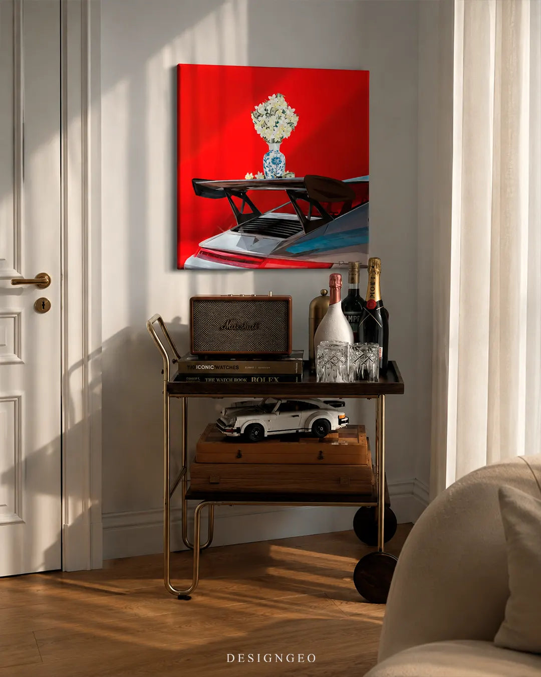 Square exotic car spoiler flower vase canvas wall art mounted on a cream wall above a brass bar cart with champagne bottles, vintage speaker, and scale model car