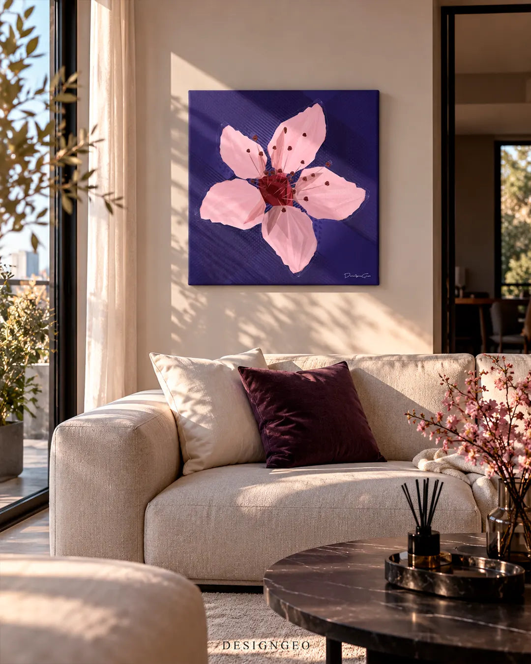 Bright sunlit living room featuring a square pink cherry blossom canvas print mounted on a neutral wall above a beige sofa with dark purple pillows