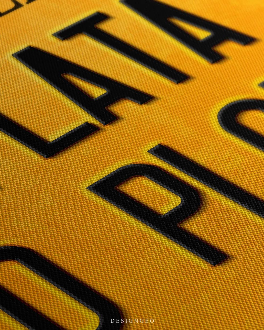 Angled close-up detail shot highlighting the black stamped lettering, subtle inner bevel shadow effect, and fine woven canvas fabric texture