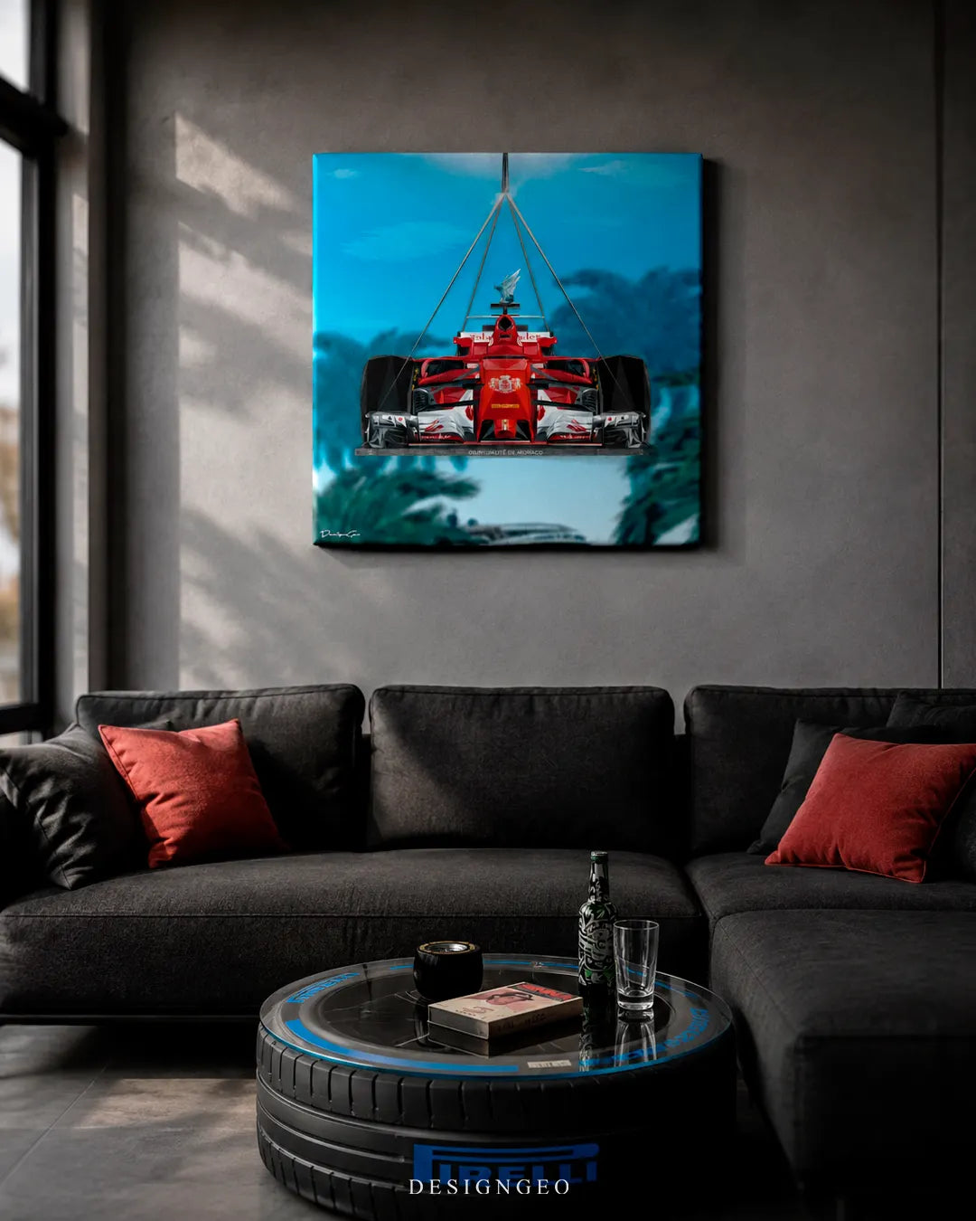 Square racing car canvas print mounted on a dark grey concrete wall above a charcoal sectional sofa with red pillows and a Pirelli racing tire glass coffee table