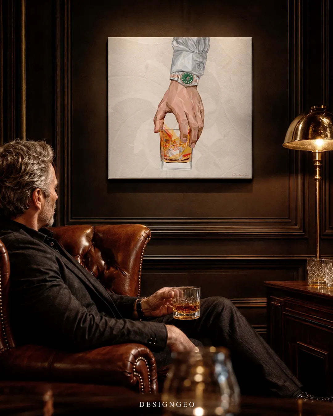 Square whiskey glass canvas wall art mounted in a dark wooden lounge above a man relaxing on a brown leather Chesterfield armchair with a drink